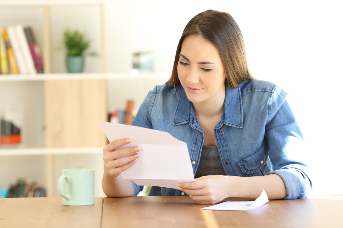 Relaxed lady reading a letter at home